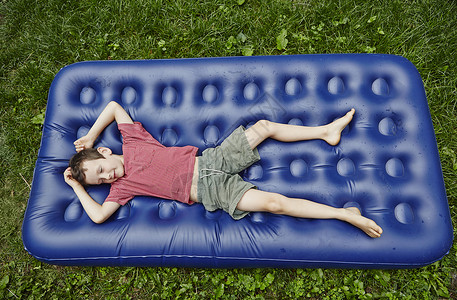 躺在充气床垫上的男孩背景图片