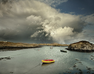 停泊在带有风暴云的天然海港的船只，巴拉岛，赫布里底群岛，苏格兰，英国图片