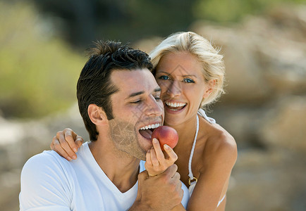 一个女人给一个拉丁男人喂油桃图片