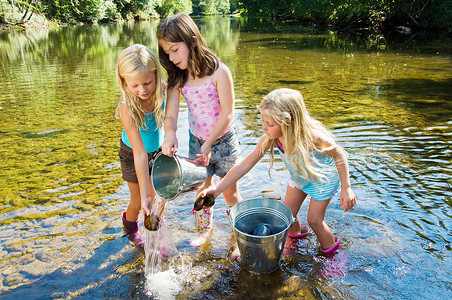 拿着水桶女孩在河里冲洗石头的女孩们背景