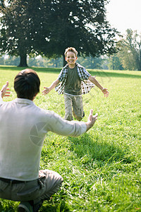儿子在公园里向他爸爸跑去图片
