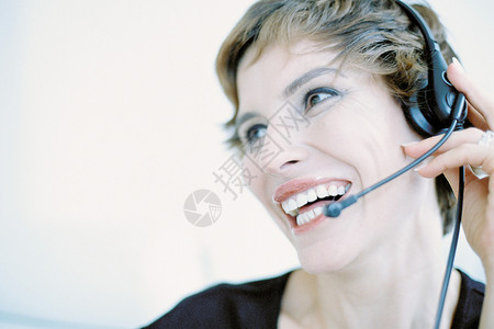 一个戴着耳机在讲电话的快乐接待员图片