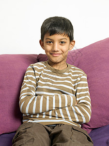 坐在沙发上微笑的男孩图片