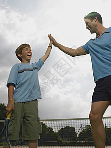 男孩在打网球父子户外打网球背景