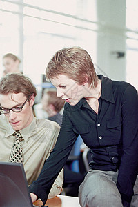 商人和女商人在办公室使用笔记本电脑背景图片