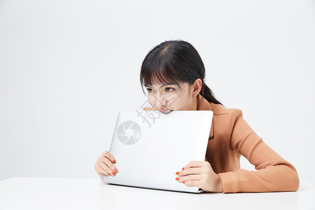 青年女性厌烦工作啃电脑背景图片