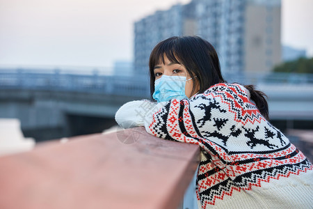 青年女性趴在栏杆上背景图片