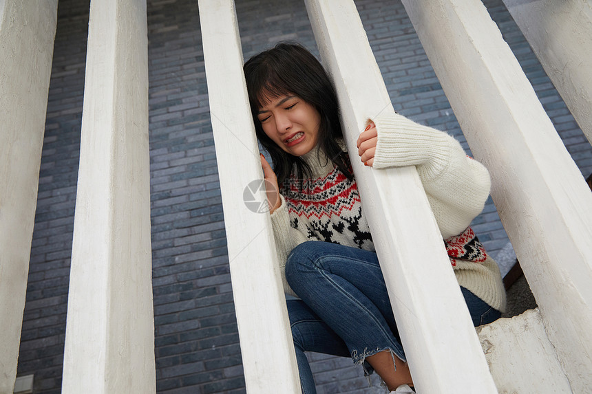 青年女性沮丧坐在楼梯上图片