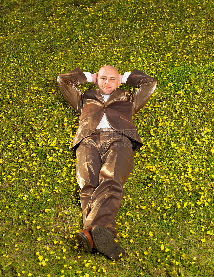 穿着西服躺在草地上的男人图片