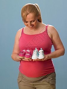 抱着婴儿鞋的孕妇图片