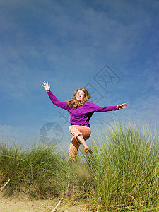 少女在草地上跳跃图片