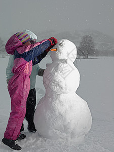 孩子玩雪女孩堆雪人背景