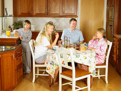 四个一回合一家人坐在餐桌旁吃饭背景