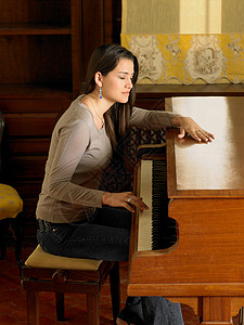 年轻女子单手弹钢琴图片