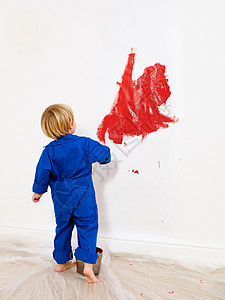 男孩把墙涂成红色图片