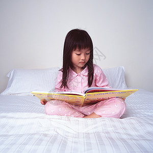 小女孩在床上看书图片