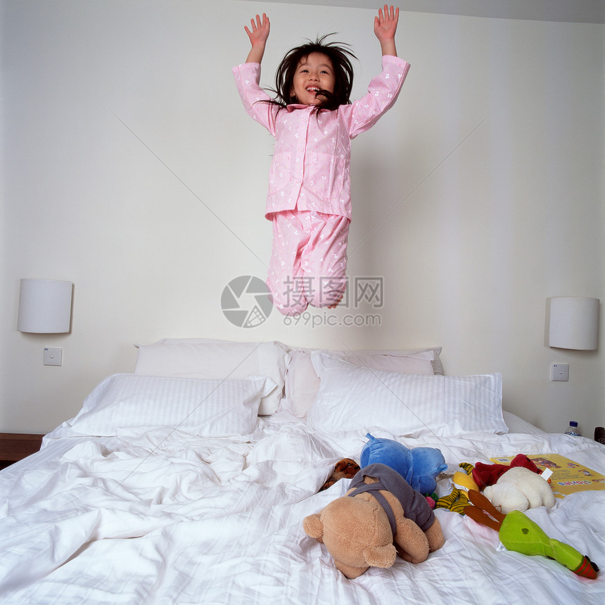 小女孩在床上跳图片