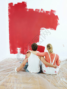 一对夫妇注视着粉刷的墙壁图片