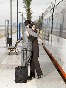 穿西装的情侣在车站拥抱图片