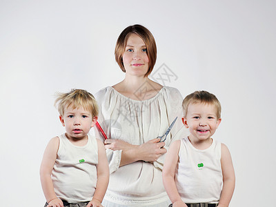 母亲和双胞胎男孩站在一起图片