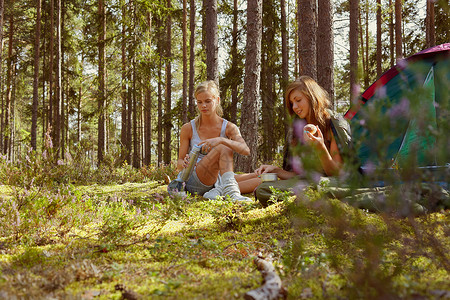 坐在森林营地的妇女图片