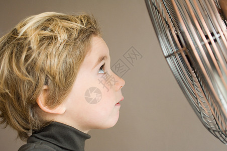 男孩盯着电风扇背景图片