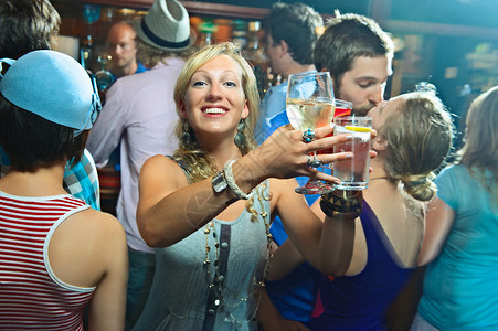 在酒吧里端酒的年轻女人背景图片
