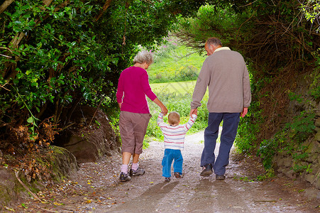 弘扬民族精神带着孩子散步的老年夫妇背景