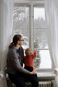 在窗台看雪的母子图片