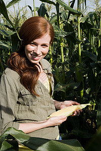 抱着玉米芯的年轻女子图片