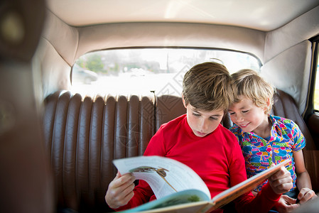 坐在车后看书的男孩们图片