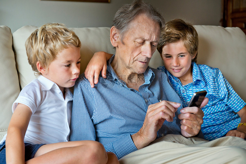 一起看智能手机的祖父和孙子图片