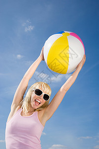 一个沙滩球带着沙滩球的年轻女子背景