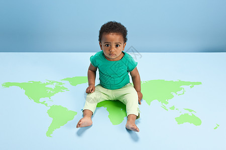 小男孩坐在地上的世界地图上图片