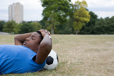 男孩在足球上休息图片