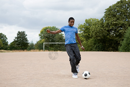 十几岁的男孩在踢足球图片
