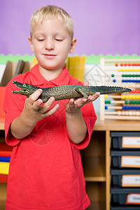 抱鳄鱼玩具的男孩图片