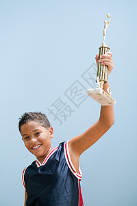 举起篮球奖杯的男孩图片