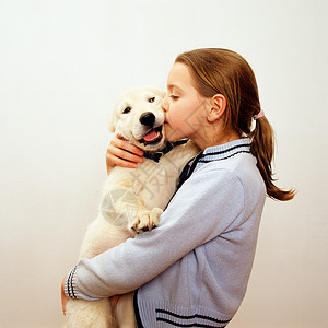 亲吻拉布拉多小狗的女孩图片