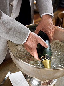 冰桶里的香槟从冰桶里拿香槟瓶的人背景