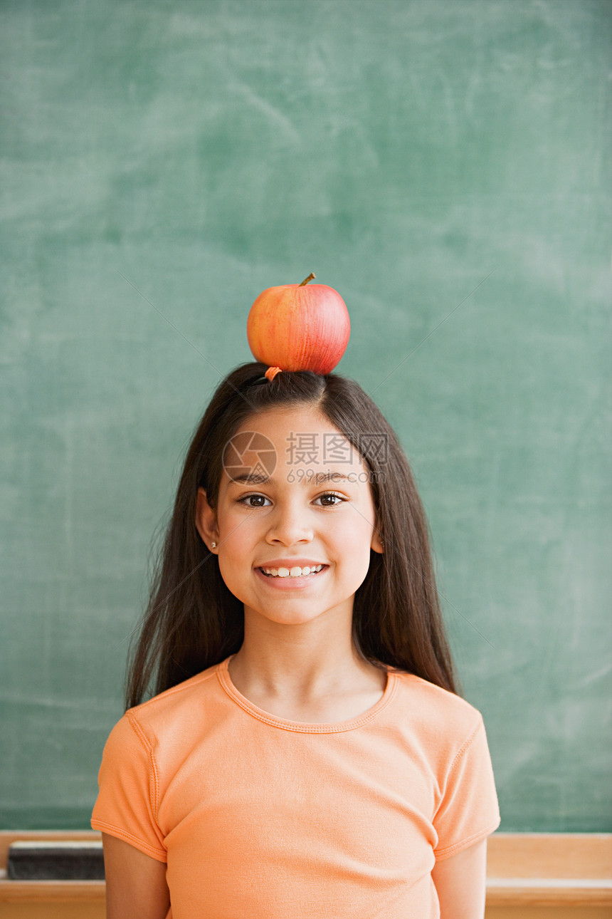 女学生在头上放一个苹果图片