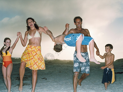在海滩上玩得开心的家庭图片