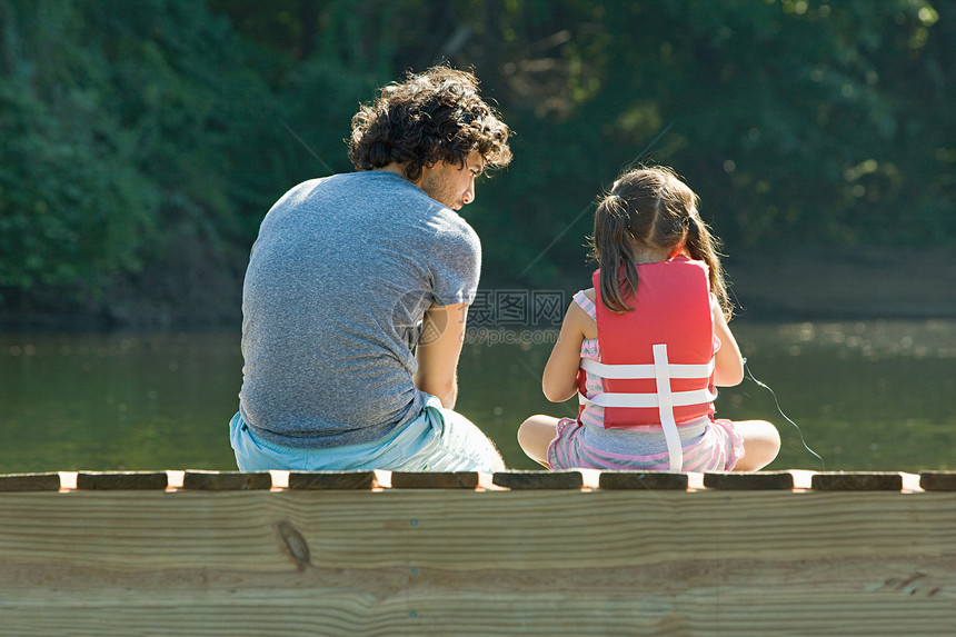 父亲和女儿在湖边的码头上图片