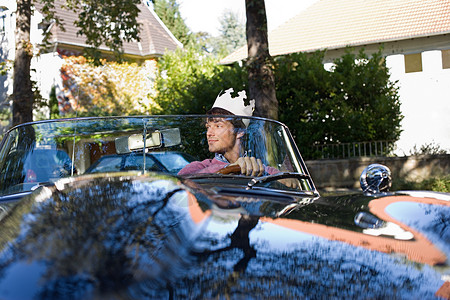 男人戴着纸王冠在开车图片