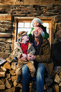一家人坐在乡村小屋的圆木上图片