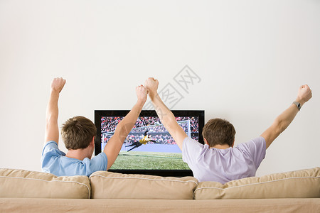 两个年轻人在电视上为足球欢呼高清图片