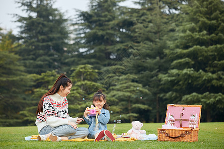 春游季节温馨母女草坪上嬉闹背景