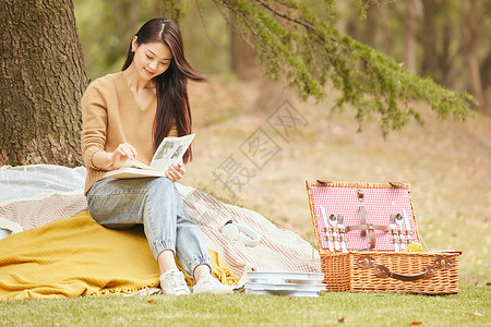 秋季野餐年轻女性树下看书背景