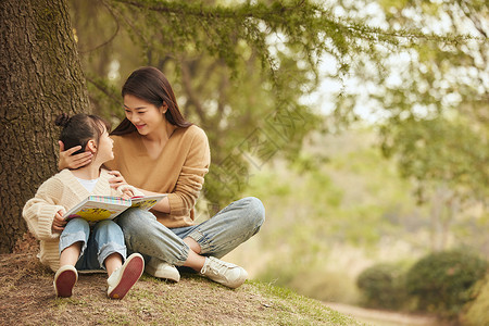 妈妈与女儿温馨母女坐在树下读书背景