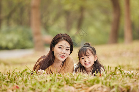 趴在妈妈背上温馨母女趴在草地上玩耍背景